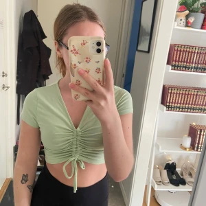 Tröja - Tröja i mintgrön köpt på VeraModa I storlek S  Går att justera rosetten där fram