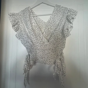 Prickig fest topp!! - Säljer denna snygga fest topp med trendigt prickigt mönster. Super bra skick. Köpt second hand så vet tyvärr inte vart den är från!! 
