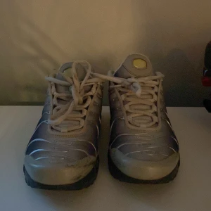 Nike Air Max Plus Tn Silver/Yellow - Nike Air Max Plus Tn sneakers i silver och svart med gula detaljer och klassisk Tn-logga bak. Snygg vågig design på ovandelen, svart sula med gula inslag och tydlig Swoosh på sidan. Skorna har snörning och meshpartier för extra komfort.