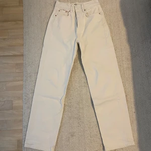 Vita jeans Gina - Ett par vita jeans/lite mer cremevita från Gina med hög midja och raka ben. I mycket fint skick, det enda är att det är svaga ”svarta” streck bak längst ner på byxan. Storlek 32 men skulle säga att de mer är som 34. Har för mig att de är en petite modell men är för långa för mig så passar nog en som är minst 160cm.