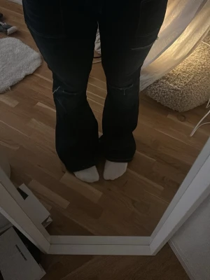 Mörkblå bootcut jeans med slitningar - Säljer ett par mörkblå bootcut jeans med snygga slitningar vid knäna. Lågmifjade ifrån Gina 14+ stl L säljer då dom är fel stl