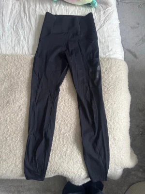 STRONGER svarta klassiska tights – storlek S - Klassiska svarta tights från Stronger i storlek S. Superskönt material med bra stretch och hög midja som sitter på plats. Perfekta för träning, gym, yoga, löpning eller som snygga vardagstights. Tidlös modell som aldrig går ur stil.  I mycket fint skick. Säljes pga kommer inte till användning.