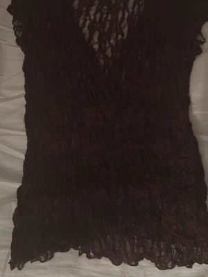 Röd spetsblus med v-ringning storlek s nelly - Snygg svart blus i spets med v-ringad omlottfront och korta ärmar. Transparent material som ger en elegant och trendig look. Perfekt att styla med jeans eller kjol för en cool outfit.