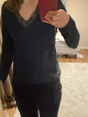 Mörkblå spetsdetaljerad topp Gina Tricot - Snygg mörkblå topp från Gina Tricot med v-ringning och spetsdetaljer vid halsen. Liknar intimissimis tröja! Långärmad modell i mjukt material som sitter bekvämt och har en elegant touch med spetsen. Perfekt för dig som vill ha en stilren men ändå trendig look.