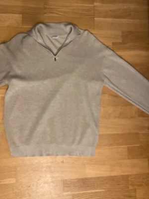 Beige halvzip tröja med krage - En stilren beige tröja med halvzip och hög krage. Perfekt för en stilren look och enkel att matcha med olika outfits.