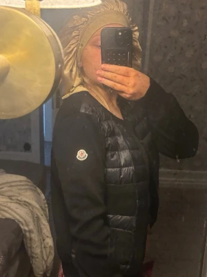 Moncler cardigan(kvitto finns) - Moncler cardigan i färgen svart, iprincip i nyskick ända defekten är att moncler loggan/lappen i nacken har lossat på ena sidan, men de går självklart att sy på igen och de är inget som syns när man har på sig den då de sitter på insidan. Har äkthetsbevis i form av orginalkvitto och prislapp❤️   Kommer bara sälja till ett bra pris då denna är i väldigt fint skick samt väldigt efterfrågad.
