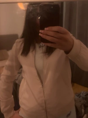 Ljusrosa bomberjacka med dragkedja - Snygg ljusrosa bomberjacka med dragkedja framtill och ribbade muddar vid ärmslut och midja. Jackan har en klassisk bomberpassform och är perfekt för dig som vill ha en stilren och enkel look. Passar till det mesta och är lätt att matcha.