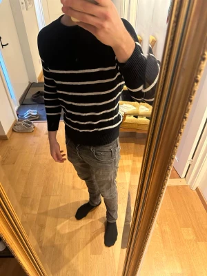 Marinblå randig linnetröja Suitsupply - Säljer en marinblå stickad tröja från Suitsupply i storlek L. Tröjan är gjord i linne och har vita horisontella ränder över hela plagget. Klassisk rund halsringning och ribbade muddar vid ärmslut och nederkant. Perfekt för dig som gillar stilrena basplagg. Nypris ligger 1799kr 