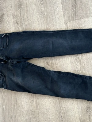 Svarta skinny jeans från replay  - Säljer ett par svarta skinny jeans från replay med klassisk femficksdesign och smal passform. Jeansen har en diskret tvättad look och är tillverkade i mjukt bomullsjeansmaterial. Perfekta för dig som gillar en tajt siluett och enkel stil.