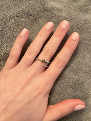 Snygg silverfärgad fidgetring med kulor - Trendig ring i silverfärgad metall med öppen design och tre små kulor på ovansidan. Ringen har en minimalistisk och modern look som passar perfekt till din vardagsstil. Enkel att matcha med andra smycken för en personlig touch. Går att justera. Vid köp av fler ringar kan jag slå ihop annonserna så frakten blir billigare.