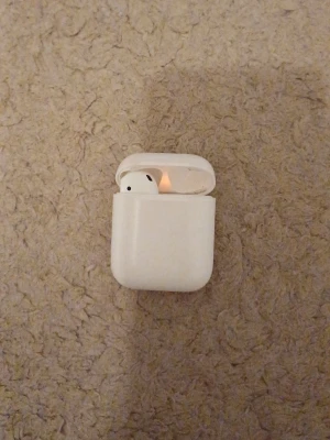 Apple Airpods - Säljer ett par vita Apple AirPods med det klassiska laddningsetuiet. Snygg och stilren design i blank plast, perfekt för dig som vill ha trådlösa hörlurar till mobilen eller datorn. Smidig att ta med överallt och enkel att använda. Fungerar super bra.