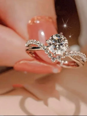 Silverring med stor gnistrande sten, justerbar  - Säljer en elegant silverfärgad ring med en stor rund gnistrande sten i mitten och mindre stenar längs bandet. Ringen har en klassisk och lyxig design som verkligen fångar ögat. Levereras i en röd sammetsask.