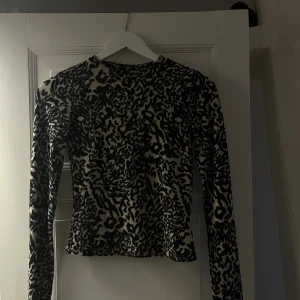 Leopardmönstrad långärmad topp - Cool långärmad topp med leopardmönster. Figurnära passform och rund halsringning. Perfekt för dig som vill sticka ut med ett djuriskt print. Inte använd många gånger 🤎🐆