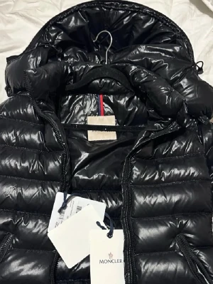 Moncler  - Moncler Bady svart. Storlek 0/XS använd fåtal gånger under förra vinter så super bra skick. Köpt här på plick och då var den som helt ny. Men det finns bevis på att den är äkta. (Skråma finns på dragkedjans dragare) Det är därför jag säljer så billigt men skråman syns knappt. 