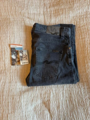 Nudie Jeans Grim Tim  - Svart/gråa Nudie Jeans Grim Tim | Färg: Dark Cove | Skick 7/10 (liten slitning vid lappen men inget som syns alls vid användning) | Storlek: 30/32 | Nypris 1700kr | Hör av er vid funderingar! | A&W fashion 🌟