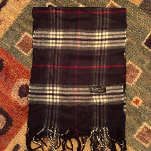 Vintage Burberry Halsduk Scarf - -Riktigt bra skick, knappt använd. Nypris på dessa ligger på runt 5000kr, vilket gör detta till ett sjukt bra pris! Halsduken är gjord i Lamull, och är perfekt inför hösten och den kommande vintern. Anledningen till att det står ”Burberry’s” och inte ”Burberry” på lappen är eftersom halsduken är från några år tillbaka, innan de bytte namn! Om du har någon fråga är det bara att skriva till mig. /elgnce (3)