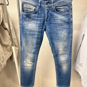 Dondup jeans George - Snygga skinny jeans från Dondup i ljusblå tvättad denim med slitningar och blekta detaljer. Klassisk femficksmodell med gult kontrastsömmar och croppad längd. Perfekta för en avslappnad streetstil. Midja: 30 och längden är 90cm