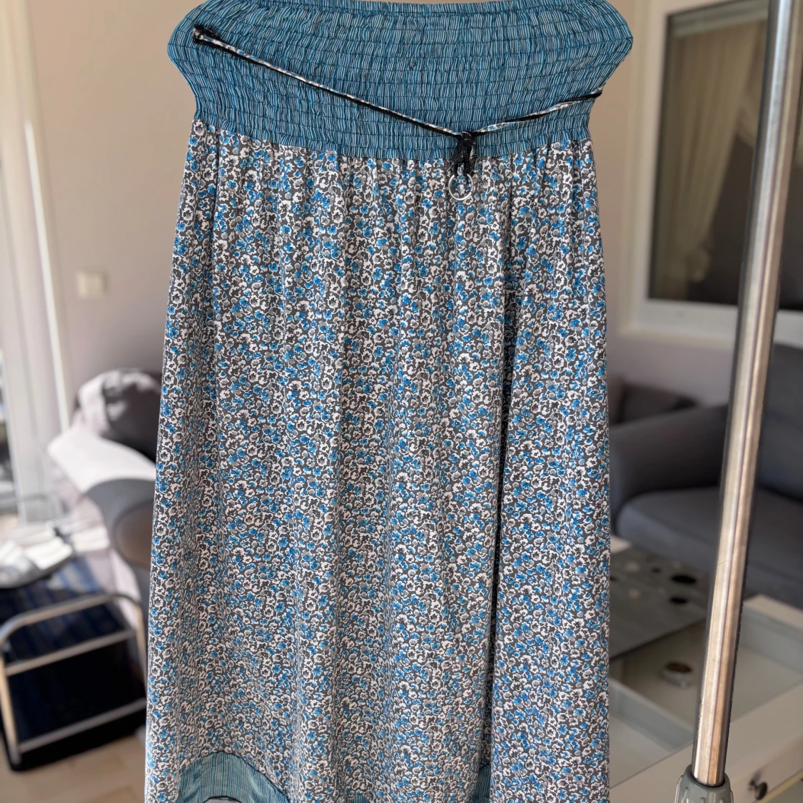 Blommig plagg med blå detaljer (används som både kjol och sommarklänning)