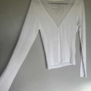 Uringas tröja med spets - Vit v-ringad tröja med spets, aldrig använd så den är helt ny och inga skavanker förekommer! Hör av dig vid eventuella frågor!🤍