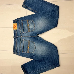 Nudie jeans  - Sjukt feta Nudie jeans med slitningar🤩. Storlek W36 L 34 men passar som W33 L32. Perfekta för en snygg stil i skolan, på jobbet eller till en utekväll🍾🤙Kom DM vid frågor