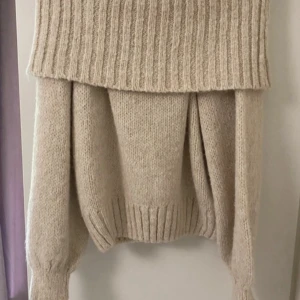 Beige stickad tröja från Gina Tricot - Mysig beige stickad tröja från Gina Tricot med bred ribbad kant nertill och vid ärmslut. Tröjan har en relaxed passform och är perfekt för lager-på-lager. Superskön och enkel att styla till jeans eller kjol.