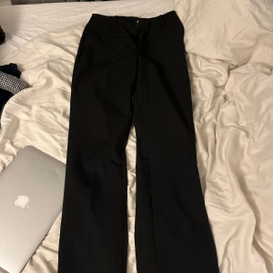 Svarta kostymbyxor från Bik Bok - Svarta kostymbyxor från Bik Bok i storlek 38. Sitter super bra i längden för mig som är 172!