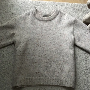 Cream vit  stickad tröja Carin Wester  - Säljer en  stickad tröja från Carin Wester i storlek M. Tröjan har ett spräckligt mönster med små färgprickar i blått, rött, grönt och gult. Rund hals och ribbade muddar vid ärmsluten, är VÄLDIGT skön enligt mig oxh värmer bra under hösten och vintern SKRIV FÖR FLER BILDER