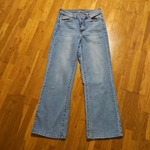 Ljusblå wide jeans från H&M, stl 38 - Ljusblå jeans från H&M i klassisk denim med raka, vida ben och normal midja. Jeansen har fem fickor och subtila slitningar framtill för en avslappnad look. Perfekta för dig som gillar en loose och trendig stil.