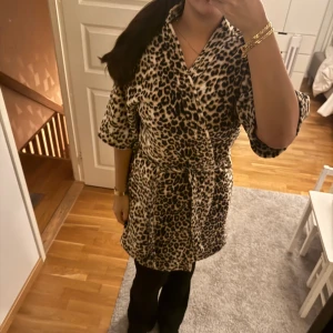 Leopardmönstrad morgonrock  - Säljer en snygg leopardmönstrad morgonrock  med omlottmodell och knytband i midjan. Morgonrocken  har trekvartsärmar och är i mjukt, skönt material. Perfekt för dig som vill sticka ut med ett djurmönster och gillar bekväma plagg med cool attityd.
