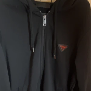 Prada zip Hoodie - Svart hoodie från Prada med klassisk huva, snörning och dragkedja framtill. Först till kvarn, passa på!🚀