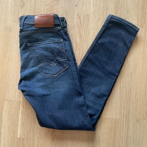 Mörkblå Replay Anbass jeans W30 L32 - Jag säljer dom här riktigt snygga Replay Anbass jeansen som är i storlek W30 L32. De är inte använda mycket alls och är i väldigt fint skick utan skador och defekter. Tveka inte att höra av er!                                                                                   Mått: Längd=104cm. Midja=40cm