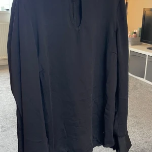 Svart henley-skjorta från AWARE XS - Svart blus från AWARE, köpt från Vero Moda  i storlek XS. Långa ärmar och en stilren, enkel design med rundad hals och öppning framtill. Materialet känns mjukt och lätt, säljer för den inte kommer till användning längre. Använt den kanske 2-4 gånger💕💕