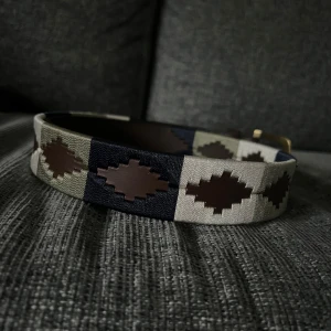 Mönstrat bälte från Pampeano - Snyggt bälte från Pampeano med geometriskt mönster i mörkbrunt, beige och marinblått. Bältet har detaljer i skinn och textil, samt ett klassiskt spänne i metall. Perfekt accessoar för att lyfta din outfit med en unik touch. passar på 25-32 i midja, kontakta för mer info om just din storlek.