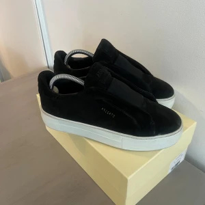 Svarta Axel Arigato skor - Snygga svarta mocka sneakers från Axel Arigato med vit sula i storlek 37. Endast använt 2-3 gånger! 