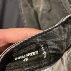 Svarta distressed jeans från Dsquared2 - Svarta jeans från Dsquared2 i storlek 46 med snygga slitningar och hål för en riktigt edgy look. Jeansen har klassisk femficksdesign, smal passform och är tillverkade i denim. Perfekta för dig som gillar streetstyle och vill sticka ut.