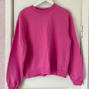 Rosa sweatshirt i bomull - Enkel och snygg rosa sweatshirt med rund hals och långa ärmar. Tröjan har ribbade muddar vid ärmslut och nederkant. Perfekt för dig som gillar färg och vill ha en basic tröja i garderoben. Tillverkad i mjuk bomull för skön känsla.