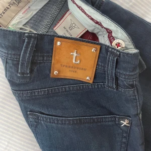 Tramarossa Jeans - Säljer nu ett par fantastiska jeans i sjukt bra skick. | Sjukt snygg mörkblå tvätt med snygga detaljer. Patchen där bak är i mocka med silvriga detaljer. | Hör av er vid frågor!🌟