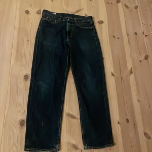 Levi's Premium 501 jeans mörkblå - Mörkblå Levi's Premium 501 jeans med klassisk femficksdesign och raka ben. Jeansen har en snygg tvätt och tydliga kontrastsömmar. Tillverkade i slitstarkt bomullsjeansmaterial och har den ikoniska läderpatchen bak i midjan.