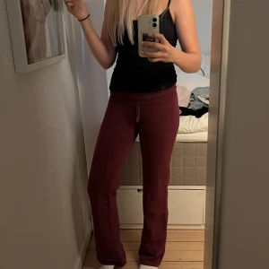 Vinröda mjukisbyxor - Säljer ett par vinröda mjukisbyxor med bootcut-snitt och snörning i midjan. Byxorna har en skön loose passform och är perfekta för chill dagar. Tillverkade i mjukt material som känns bekvämt mot huden.