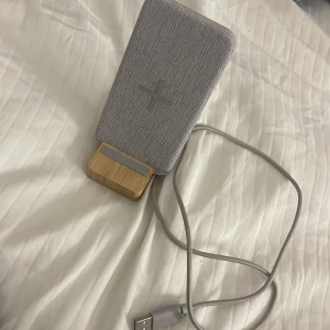 Trådlöst laddningsställ - Stilren trådlös laddare från IKEA, modell NORDMÄRKE. Kan också användas som mobil ställ. Mycket gott skick, inga synliga defekter eller slitage. 