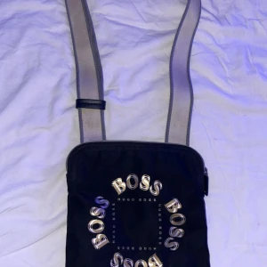 Svart axelväska från Hugo Boss - Säljer min Hugo boss axelväska. Den går ej att köpa nåmer det finns inga skador på den.