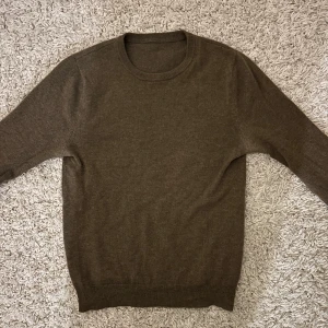 Brun stickad tröja av 100% cashmere  - Skit snygg brun stickad kofta från John Henric, 100% cashmere den har en vanlig passform dock lite krympt i tvätten. Enda fel är att den har ett litet hål på undersidan av armen (syns dock inte när man har på den)