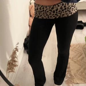 Svarta yogapants med leopardmidja - Säljer dessa svarta yogapants med bred, låg midja i beige tyg med leopardmönster. Stretchigt material som sitter skönt💕Har sytt fast leopardmönstret själv och byxorna är köpta ifrån Gina Tricot💗