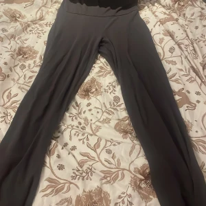 Svarta vida yoga pants från H&M - Svarta yogapants från H&M i storlek 146/152 och är tillverkade i mjuk bomull med stretch för extra komfort. Byxorna har ett rakt och lite vidare ben, perfekt för en avslappnad och trendig look.