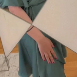 Grön omlottklänning med knytband - Snygg grön omlottklänning med knytband i midjan och korta ärmar. Klänningen har en elegant v-ringning och ett flowy fall som ger en avslappnad men chic look. Perfekt för dig som gillar stilrena och trendiga plagg.