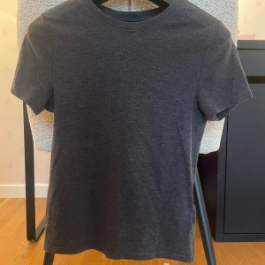 Mörkgrå basic t-shirt - Mörkgrå t-shirt som sitter tight. T-shirten är i mjukt material och har en tight passform som funkar till det mesta.
