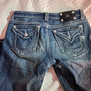 Miss Me Low Waist Jeans - Snygga blå jeans från Miss Me med tydliga slitningar. Vill helst att någon annan fixar dem än jag eftersom dem är för små🙏🏼 Varit mina favorit jeans i 2 år.❤️Låg midja och bootcut passform. !!!⚠️ORIGINAL PRIS: 800kr ⚠️!!!