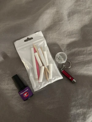 Tandkristaller med lim och verktyg - Säljer ett kit för tandkristaller som innehåller små glittriga kristaller i olika färger, lim i lila flaska, verktyg som träpinnar och pincett samt en liten led lampa för applicering. 