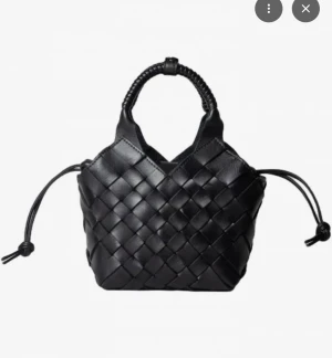 Svart handväska från Cala Jade byta  - BYTER svart cala jade väska super bra skick kan tänka mig byta mot lite vad som -mini-format med flätad design och snygga detaljer. Väskan har två handtag med snörning och en justerbar axelrem. Tillverkad i skinn och har en stilren look som sticker ut.