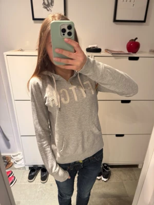 grå abercrombie & fitch hoodie - grå abercrombie & fitch hoodie!                        Storlek L men passar bättre en vanlig S.                 Bra skick lite slitet på logan som ses på bilderna!